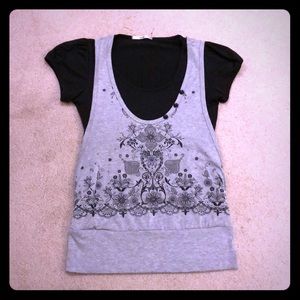 Black shirt bound by wide waistband to grey vest.